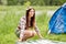 Happy young woman laying blanket at campsite