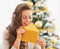 Happy young woman licking envelope near christmas tree