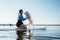 Happy Young Woman with Locs Hugging with Her Dog Japanese Spitz While Sitting on the Sup Board on the Lake