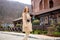 Happy young woman with long red straight hair wearing beige coat walking in town