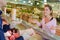 Happy young woman looking at sliced meat at butchery