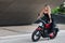 Happy young woman mounting on a red motorbike