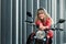 Happy young woman mounting on a red motorbike