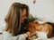 Happy young woman playing with her dog on a white background. Beagle dog with owner. Girl and dog at home