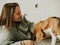 Happy young woman playing with her dog on a white background. Beagle dog with owner. Girl and dog at home