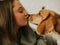 Happy young woman playing with her dog on a white background. Beagle dog with owner. Girl and dog at home