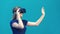 Happy young woman playing on VR glasses indoor. Virtual reality concept with young girl having fun with headset goggles
