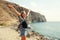 Happy young woman raises hands up over sea and mountain background, Tenerife, Canary Islands