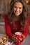 Happy young woman in red dress having christmas snack