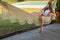 Happy young woman relaxed lies in a hammock on the balcony House. Woman basks and sunbathes in a hammock