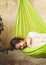 Happy young woman relaxing in a hammock on the terrace house.