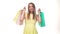 Happy young woman shopper holding shopping bags on white background in studio.