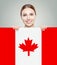 Happy young woman showing the Canada flag background. Live, work