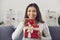 Happy young woman showing red heart and Valentine gift, smiling and saying thank you for present