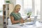 Happy young woman sitting at desk at home reading official document with good news