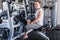 Happy young woman sitting on exercising bench. She`s smiling and looking at camera