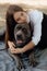 Happy young woman sitting on the grass hugging a dog. Love and affection for pets, friendship companion. dog breed - cane corso