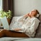 Happy young woman sitting on sofa in headphones using laptop. Woman or teen girl resting, bliss enjoy listening to music on couch