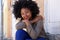 Happy young woman sitting on steps leaning head on hand