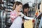 Happy Young Woman Slicing Cheese With Knife In Shop