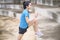 Happy young woman in sportswear is exercising in park