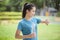 Happy young woman in sportswear using smart watch while exercising in park