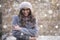 Happy young woman standing outside and getting cold while snowing