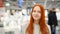 Happy young woman is standing in a shopping mall