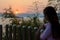 Happy young woman standing watching the sunset over the lake