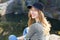 Happy young woman in a stylish blazer posing on a background of mountains and forest - active resting concept