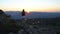 Happy young woman on the sunset high in the mountains with open waving hands