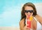 Happy young woman in swimsuit drinking cocktail