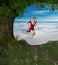 Happy Young Woman on Swing under a Tree