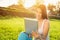 Happy young woman with tablet in park on sunny summer day