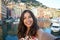 Happy young woman tanned taking selfie photo in a typical italian landscape with harbour and colorful houses for italian holidays