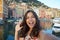 Happy young woman tanned taking selfie photo in a typical italian landscape with harbour and colorful houses for italian holidays