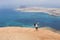 Happy young woman on the top of a mountain over panoramic view of canary islands. Clear blue sky and sea. Wind. TRavel and