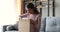 Happy young woman unpacking delivery parcel box at home