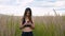 Happy young woman use smartphone and headphone walking in field at sunset, healthy lifestyle. Sportywoman runner using