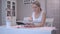 Happy young woman using her tablet while sitting at the craft table