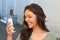 Happy young woman using a smart phone in the street with an unfocused background taking a selfie or using Skype or making a video