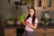 Happy young woman with vegetable on kitchen. Cheerful youthful female enjoying healthy lifestyle while holding bell