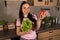 Happy young woman with vegetable on kitchen. Cheerful youthful female enjoying healthy lifestyle while holding bell