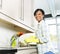 Happy young woman washing dishes