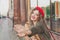 Happy young woman wearing red french beret waving hello