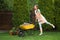 Happy young woman with wheelbarrow working