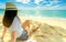 Happy young woman in white shirts and shorts sitting at sand beach. Relaxing and enjoying holiday at tropical paradise beach with