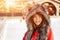 Happy young woman in a wolf hat in winter at the ice rink