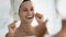 Happy young woman wrapped in bath towel flossing white healthy