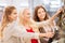 Happy young women choosing clothes in mall